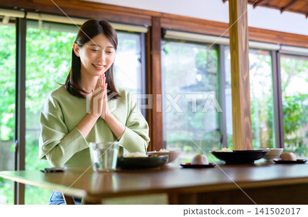 Japanese woman puts her hands together before eating Japanese woman puts her hands together before eating 141502017