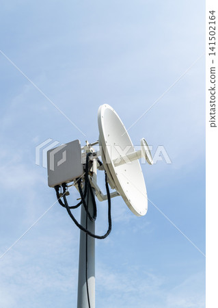 Satellite communication dish antenna mounted pole against blue sky supporting wireless network broadcasting telecommunications data transmission 141502164