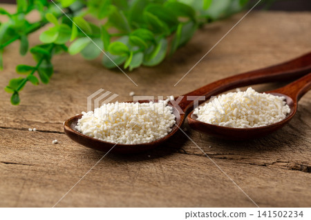 chicken bouillon granules in wooden spoons, granular chicken essence seasoning for cooking, umami flavor enhancer on rustic wood. chicken bouillon granules in wooden spoons, granular chicken essence seasoning for cooking, umami flavor enhancer on rustic wood. 141502234