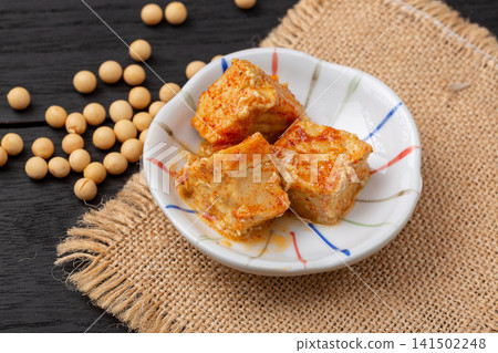 fermented bean curd in spicy chili oil, traditional Chinese sufu or chaozhou tofu on a white plate, gourmet Asian snack. fermented bean curd in spicy chili oil, traditional Chinese sufu or chaozhou tofu on a white plate, gourmet Asian snack. 141502248
