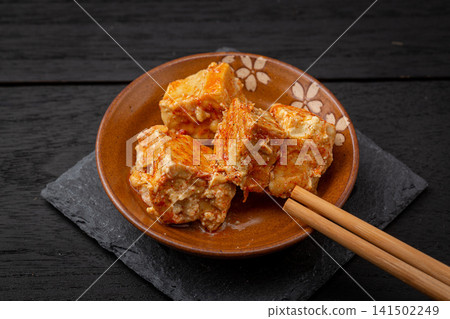 fermented bean curd in spicy chili oil, traditional Chinese sufu or chaozhou tofu on a white plate, gourmet Asian snack. fermented bean curd in spicy chili oil, traditional Chinese sufu or chaozhou tofu on a white plate, gourmet Asian snack. 141502249