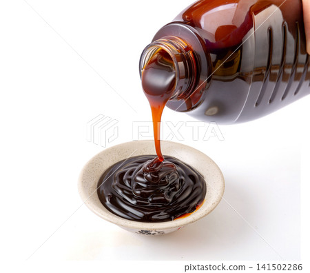 thick premium oyster sauce pouring, rich savory umami condiment for authentic Asian stir-fry and glazing. 141502286