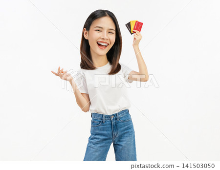 Happy young Asian woman holding credit cards with a confident smile isolated on white background. 141503050