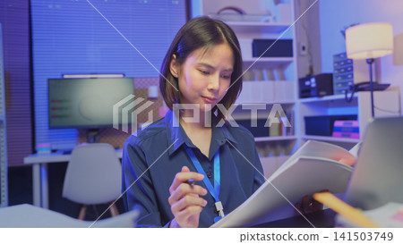 Young Asian businesswoman reviewing documents while working in office, business administration and paperwork concept. Young Asian businesswoman reviewing documents while working in office, business administration and paperwork concept. 141503749