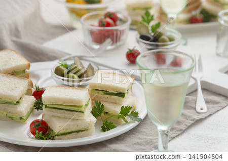 Table setting for cucumber sandwiches and light snacks to enjoy with wine. Table setting for cucumber sandwiches and light snacks to enjoy with wine. 141504804