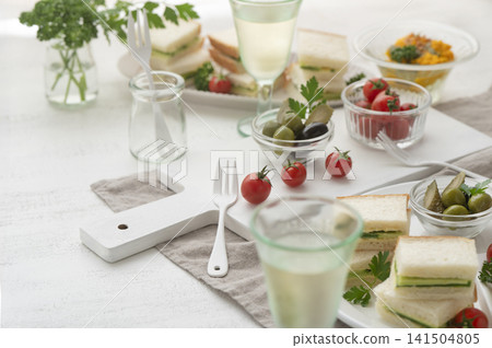 Table setting for cucumber sandwiches and light snacks to enjoy with wine. Table setting for cucumber sandwiches and light snacks to enjoy with wine. 141504805
