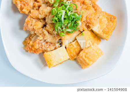 雞肉用磨碎的白蘿蔔醬汁燉煮,配上炸豆腐——一道日式小菜。 雞肉用磨碎的白蘿蔔醬汁燉煮,配上炸豆腐——一道日式小菜。 141504908