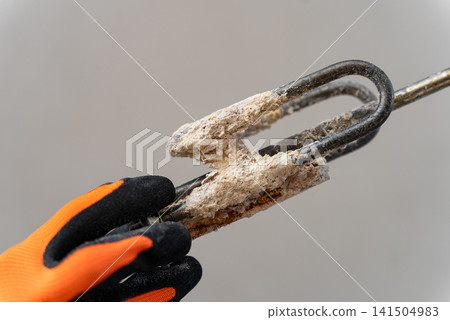 Removed Water Heater Heating Element Covered With Heavy Limescale From Hard Water. Closeup Highlighting Mineral Deposits, Component Damage And Appliance Maintenance. Removed Water Heater Heating Element Covered With Heavy Limescale From Hard Water. Closeup Highlighting Mineral Deposits, Component Damage And Appliance Maintenance. 141504983