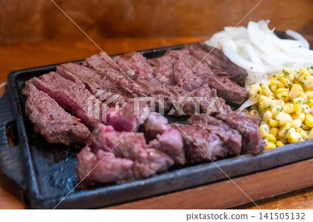 Rare meat steak grilling on pan with onion and corn Rare meat steak grilling on pan with onion and corn 141505132