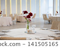 Elegant wedding reception table setting with red flowers and soft lighting 141505165