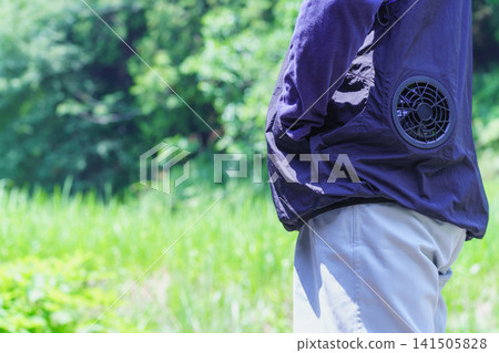 A man's back view wearing fan-equipped clothing to prevent heatstroke. A man's back view wearing fan-equipped clothing to prevent heatstroke. 141505828