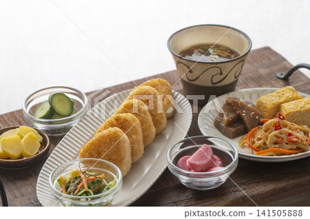 一份暖心的日式套餐,包含香氣撲鼻的烤飯糰和各種小菜。 一份暖心的日式套餐,包含香氣撲鼻的烤飯糰和各種小菜。 141505888