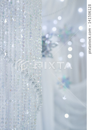 Sparkling Crystal Beaded Curtain and Blurred Snowflakes on White Sparkling Crystal Beaded Curtain and Blurred Snowflakes on White 141506128