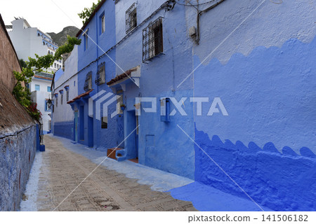 Painted blue residential houses along an empty cobblestone street in Chefchaouen Medina, Morocco Painted blue residential houses along an empty cobblestone street in Chefchaouen Medina, Morocco 141506182