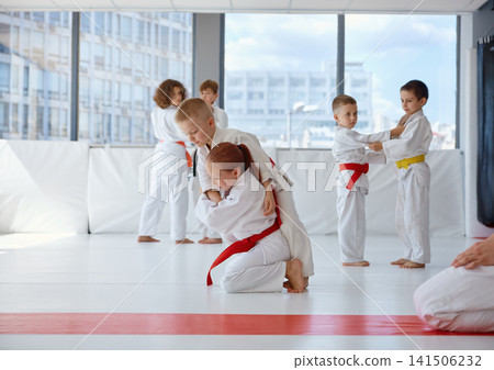 Youth martial arts, children focused on judo drills with partners Youth martial arts, children focused on judo drills with partners 141506232