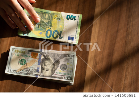 American US currency and Business concept with dollars and Euro bill banknotes American US currency and Business concept with dollars and Euro bill banknotes 141506681