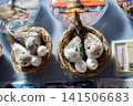 The small artificial bird nest with fake eggs in it 141506683