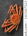 A snow crab, presented in a vibrant and luxurious manner on a slate plate. 141507523