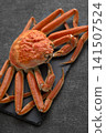 A snow crab, presented in a vibrant and luxurious manner on a slate plate. 141507524