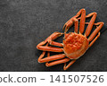 A snow crab, presented in a vibrant and luxurious manner on a slate plate. 141507526