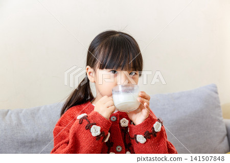 Cute Asian girl drinking milk at home, happy emotion, healthy lifestyle and childhood nutrition concept Cute Asian girl drinking milk at home, happy emotion, healthy lifestyle and childhood nutrition concept 141507848