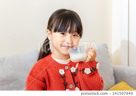 Cute Asian girl drinking milk at home, happy emotion, healthy lifestyle and childhood nutrition concept Cute Asian girl drinking milk at home, happy emotion, healthy lifestyle and childhood nutrition concept 141507849
