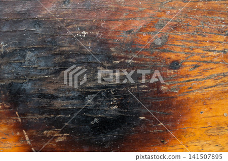 Brown wooden background with the scratch and black burning part Brown wooden background with the scratch and black burning part 141507895