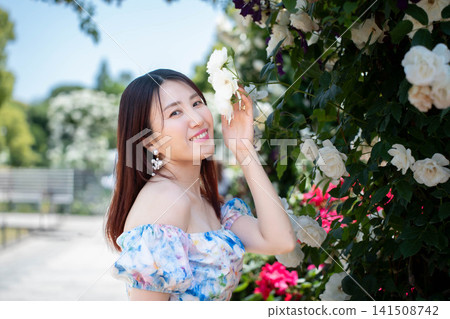 一位女士對著玫瑰花微笑。 一位女士對著玫瑰花微笑。 141508742