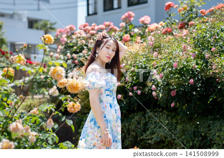 一位女士在玫瑰花前擺姿勢拍照。 一位女士在玫瑰花前擺姿勢拍照。 141508999
