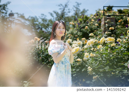 一位女士對著玫瑰花微笑。 一位女士對著玫瑰花微笑。 141509242