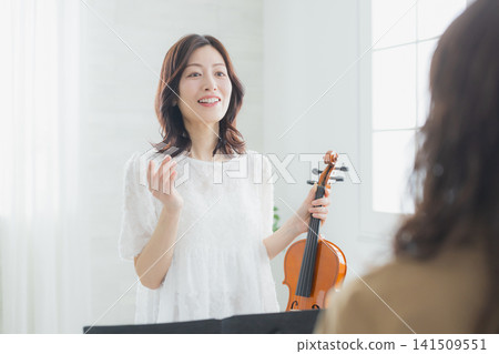 A woman practicing the violin at home. A woman practicing the violin at home. 141509551