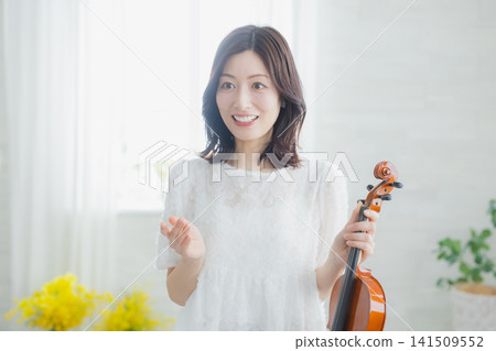 一位女士在家練習小提琴。 一位女士在家練習小提琴。 141509552