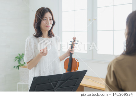 A woman practicing the violin at home. A woman practicing the violin at home. 141509554