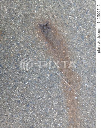 紅色的鏽跡滲入了瀝青路面表面。 紅色的鏽跡滲入了瀝青路面表面。 141509741