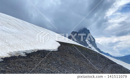 Exposed shale, lingering snow, and steep rock towers define the upper Chaukhi Pass in Georgia, providing material for geological surveys 141511079