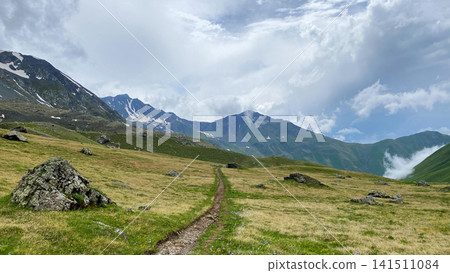 Alpine trail leads across open highland meadows on the Roshka to Juta route in Georgia, supporting hiking maps 141511084