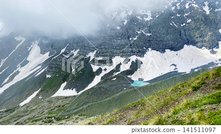 White Abudelauri Lake collects glacial meltwater beneath snow-covered cliffs in Georgia, presenting moraine terrain White Abudelauri Lake collects glacial meltwater beneath snow-covered cliffs in Georgia, presenting moraine terrain 141511097