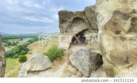 Uplistsikhe cave opening overlooks the Kura River valley from a rocky hillside in Georgia, presenting ancient settlement planning Uplistsikhe cave opening overlooks the Kura River valley from a rocky hillside in Georgia, presenting ancient settlement planning 141511114