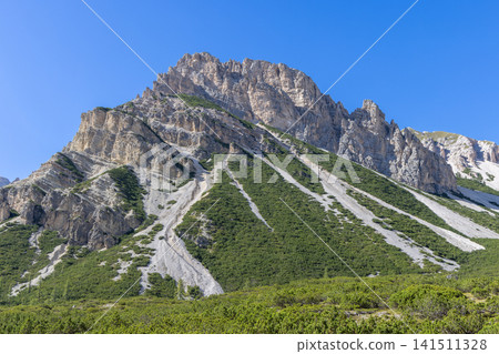 Piz de Sant Antone above dwarf pine and diagonal scree channels under clear blue sky 141511328