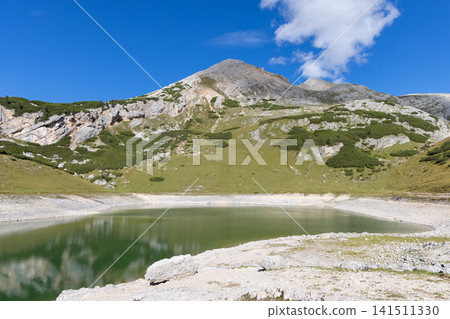 On the Fanes plateau, green Lago di Limo lies below the grassy flank of Col Bechei On the Fanes plateau, green Lago di Limo lies below the grassy flank of Col Bechei 141511330