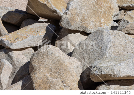 Large beige and gray boulders forming a rough natural stone background 141511345