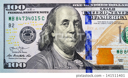 Top view of part of the $100 bill. The American national currency. Cash banknote. One hundred dollars. Economics and finance. Top view of part of the $100 bill. The American national currency. Cash banknote. One hundred dollars. Economics and finance. 141511401