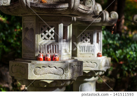 Daruma dolls on lantern in fall garden of Katsuo-ji temple, Osaka 141511593