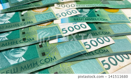 Part of the green notes in 5000 som, the current money of Kyrgyzstan. Cash banknotes of five thousand som. Kyrgyz national currency. Part of the green notes in 5000 som, the current money of Kyrgyzstan. Cash banknotes of five thousand som. Kyrgyz national currency. 141511680