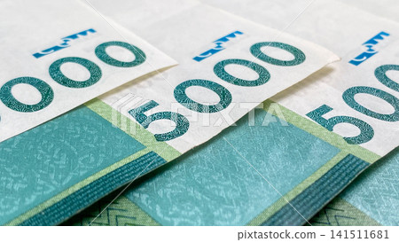 A close-up of a part of the 5000 som bills. Kyrgyz national currency. Cash banknotes. Financial business background concept. A close-up of a part of the 5000 som bills. Kyrgyz national currency. Cash banknotes. Financial business background concept. 141511681