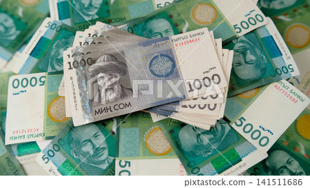 A stack of 1000 Kyrgyz som is on 5000 banknotes. Kyrgyz national currency. Five thousand som and one thousand som. Cash banknotes. A stack of 1000 Kyrgyz som is on 5000 banknotes. Kyrgyz national currency. Five thousand som and one thousand som. Cash banknotes. 141511686