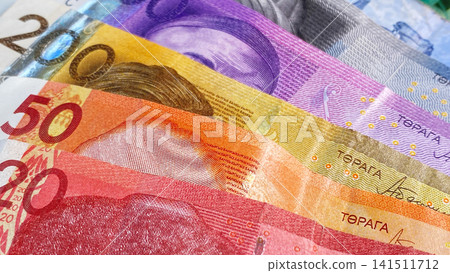 The current money of Kyrgyzstan. Multicolored banknotes in 1000, 500, 200, 50 and 20 som lie on top of each other. Savings of the Kyrgyz. The current money of Kyrgyzstan. Multicolored banknotes in 1000, 500, 200, 50 and 20 som lie on top of each other. Savings of the Kyrgyz. 141511712