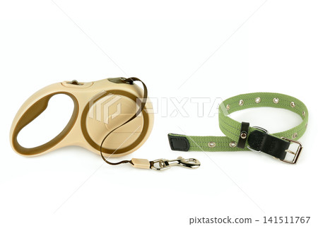 Retractable dog leash and green collar isolated on white background. Pet accessories set with extendable lead and fabric collar on white. Retractable dog leash and green collar isolated on white background. Pet accessories set with extendable lead and fabric collar on white. 141511767