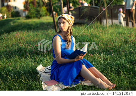 Young woman immersed in book reading. Digital detox by choice. Modern mindfulness practice outdoors on nature. Book lovers day Young woman immersed in book reading. Digital detox by choice. Modern mindfulness practice outdoors on nature. Book lovers day 141512084