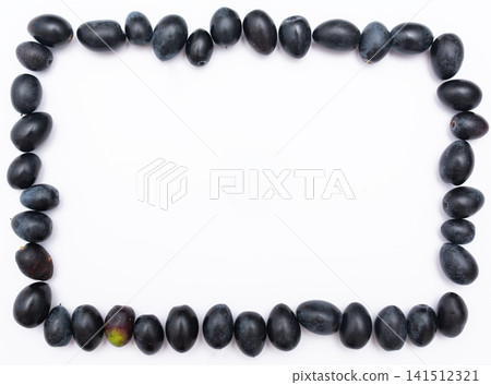 Rectangular frame made of ripe black olives on white background Rectangular frame made of ripe black olives on white background 141512321